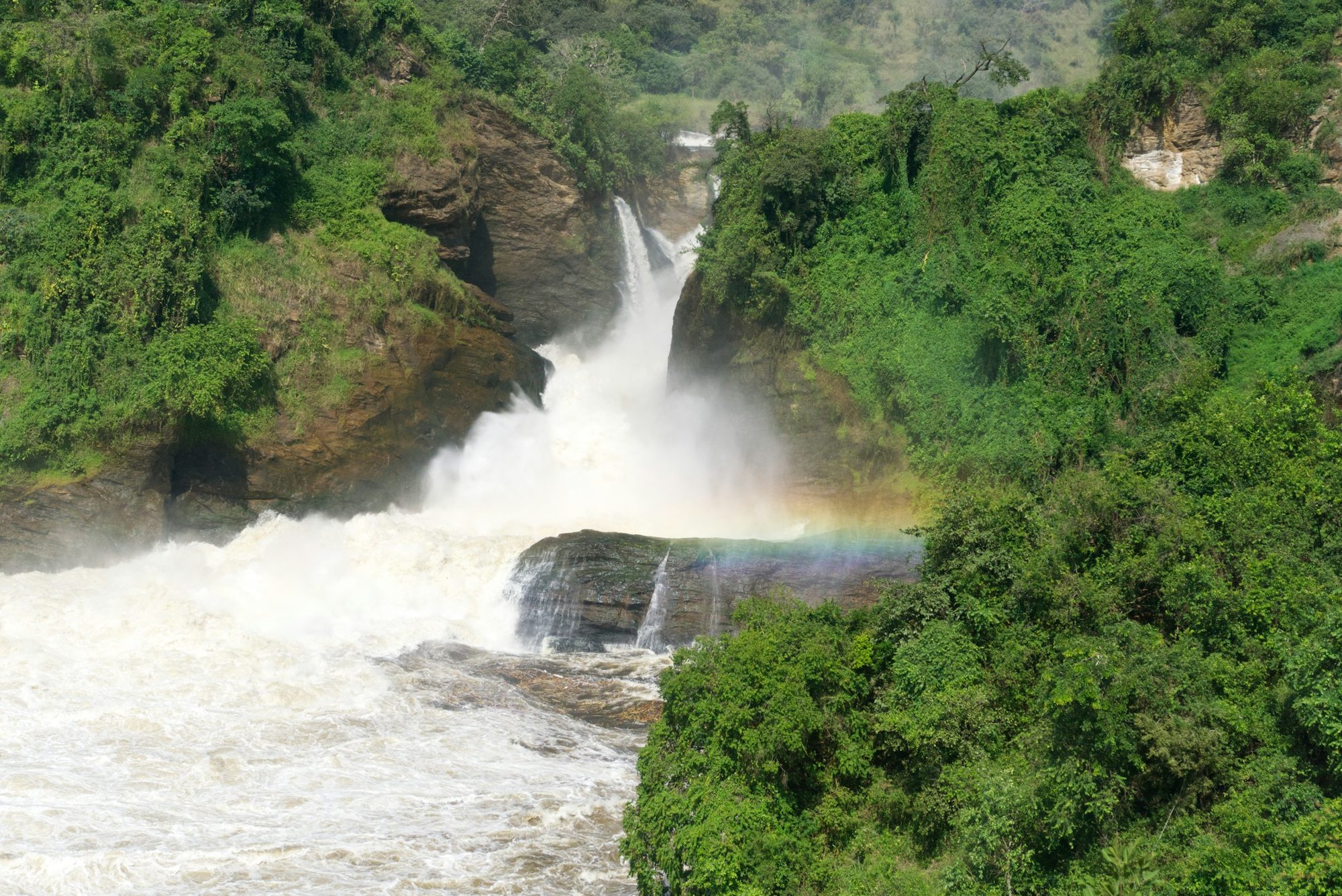 De waterval van Murchison Falls met een regenboog in het stuifwater
